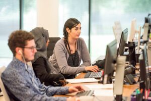 image of 3 people at computers representing small business productivity
